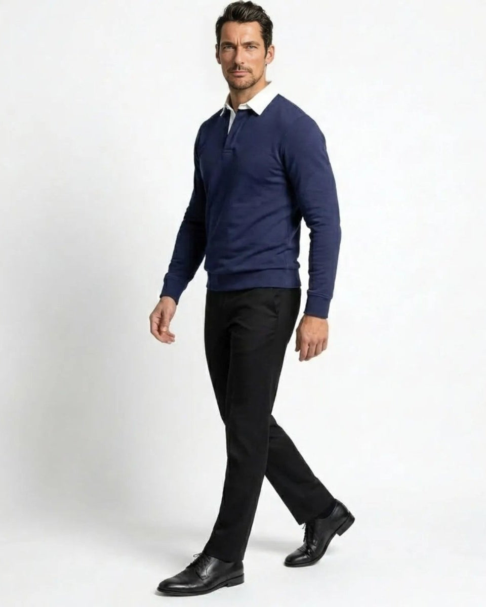 Side profile of a man walking in a navy blue smart casual long sleeve polo, demonstrating the garment's drape and silhouette.