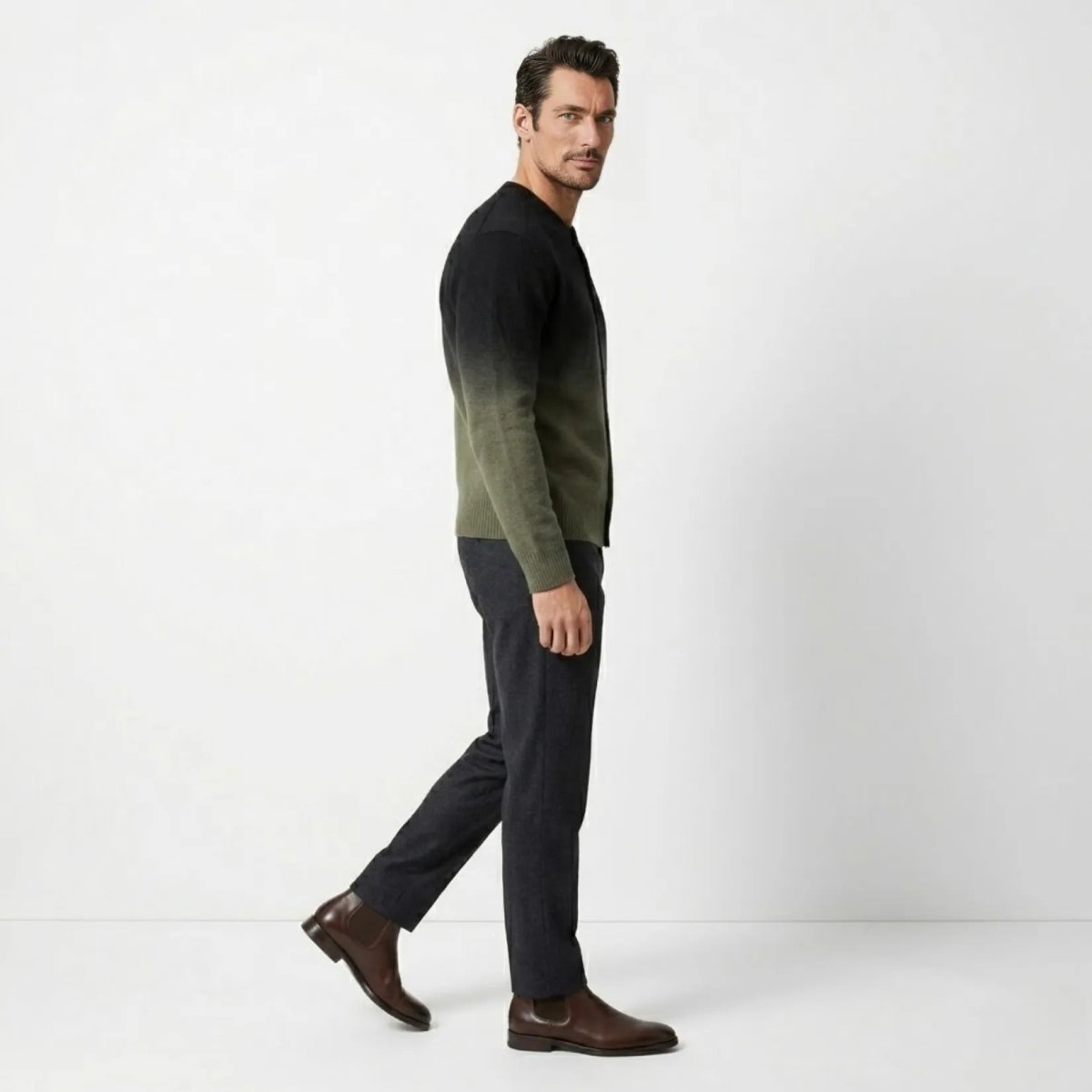 Side profile of male model walking wearing the black to green gradient button up sweater.
