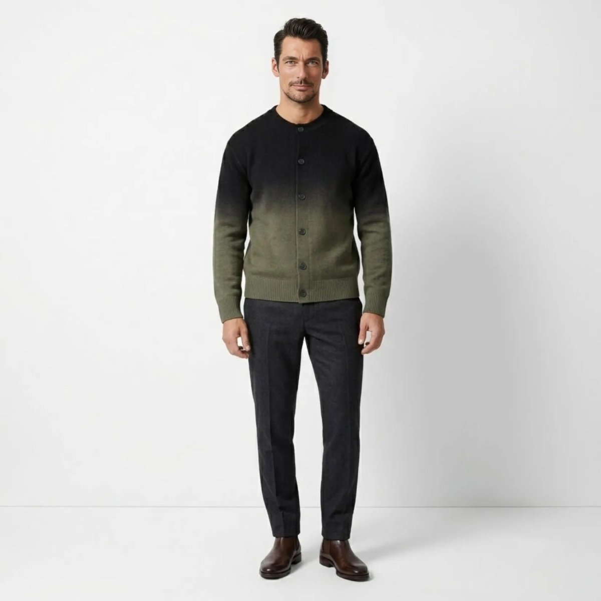 Man wearing Kouvr mens Theodore gradient knit cardigan in black and olive green with tailored trousers.