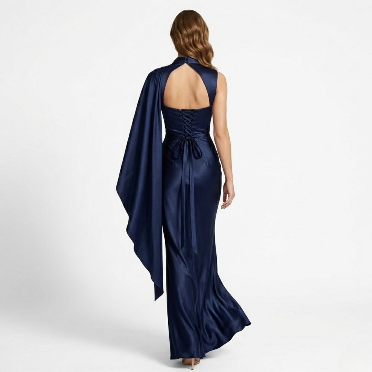 Back view of woman wearing navy blue formal dress highlighting open keyhole back and lace-up corset ties.