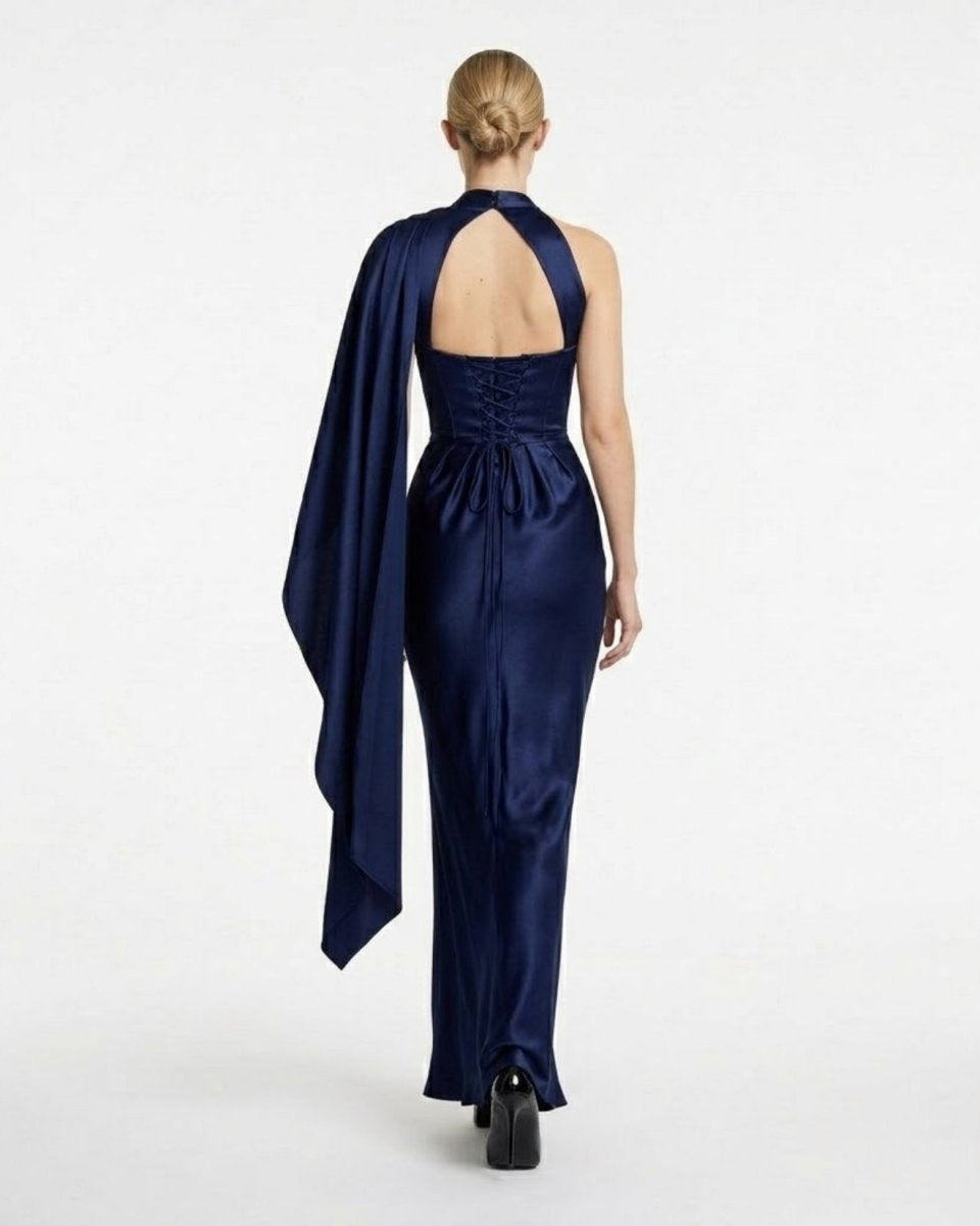 Back view highlighting the open back cutout and adjustable corset lace-up detail of the navy blue satin maxi gown.