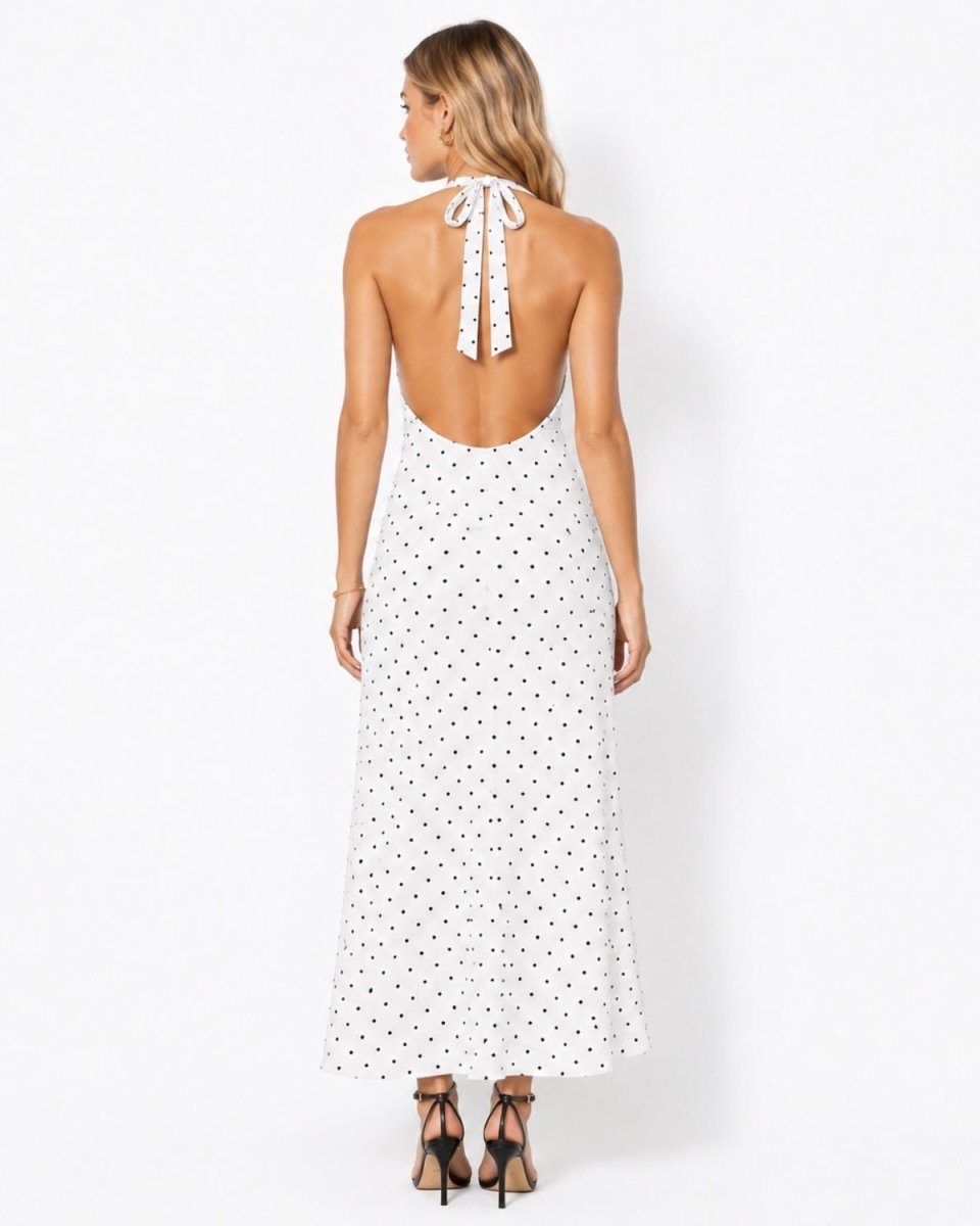 Back view of a stunning backless tie halter dress in white with black spots, highlighting the elegant bare back design.