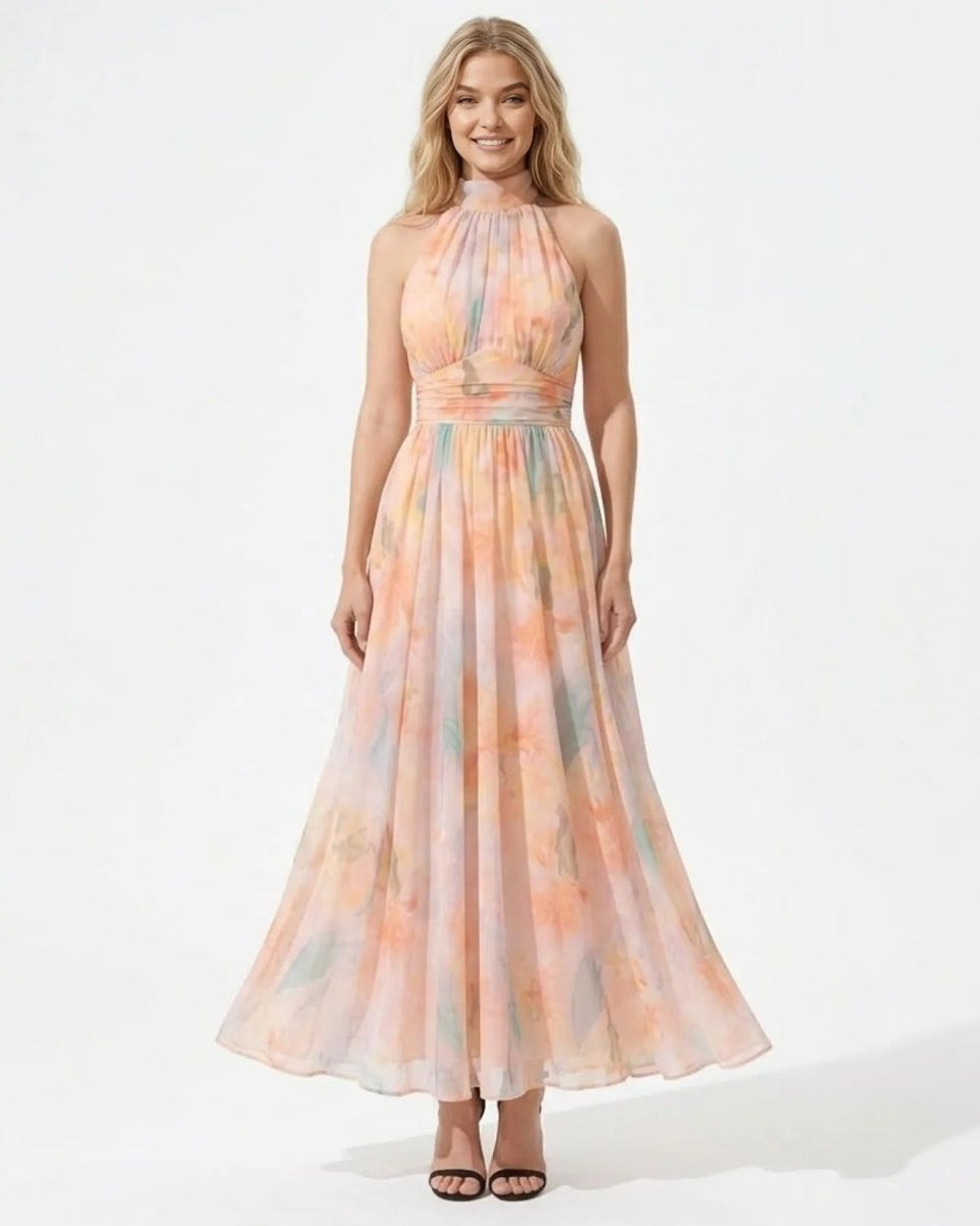 Front view of the pastel watercolor floral halter maxi dress on a blonde model smiling.