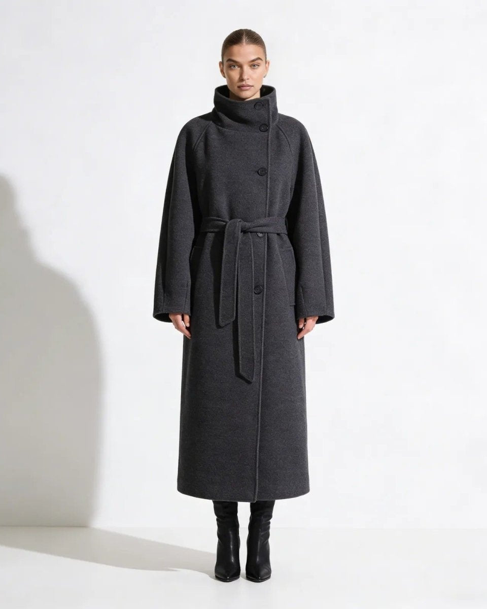 Model wearing the Patrice long gray wool coat with a high funnel neck and tied belt, shown from the front against a white background.