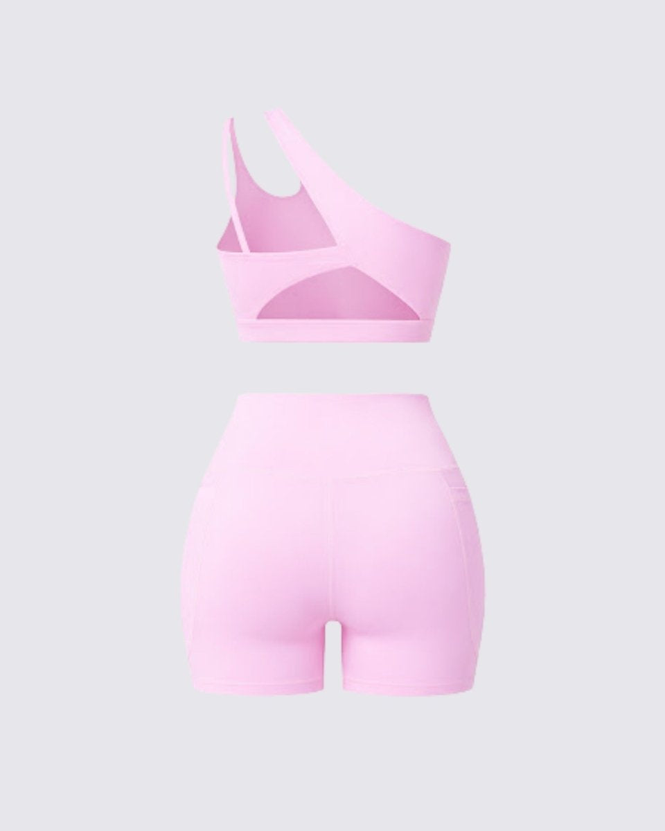Back flatlay view of a pastel pink athletic set showcasing the unique strap design and back cutout of the sports bra