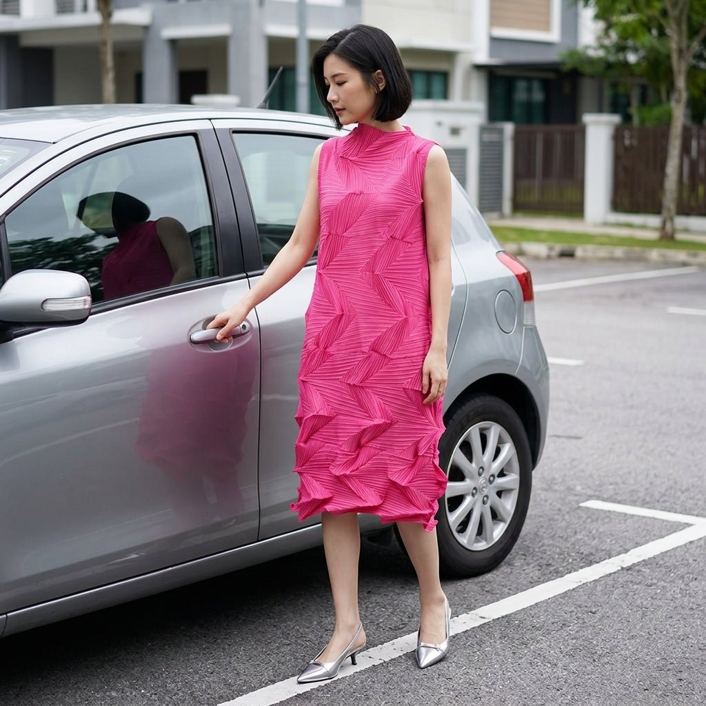 Woman opening car door wearing elegant pink pleated midi dress with silver heels.