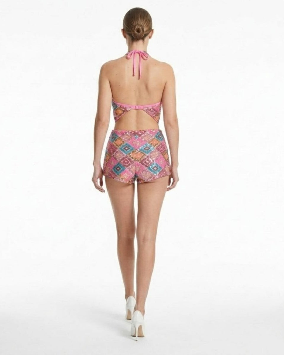 Back view of open back pink sequin mini romper showing adjustable bra-style clasp and halter neck tie fastening.