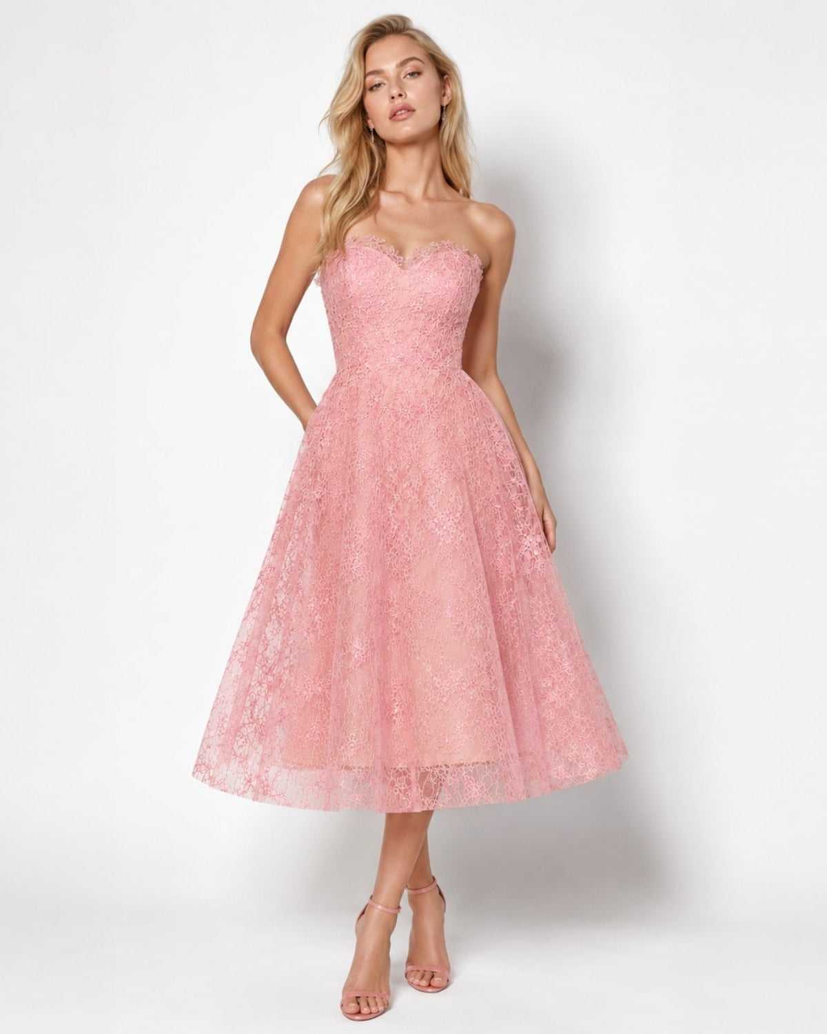 Elegant fashion model posing in blush pink strapless lace cocktail dress featuring a multidimensional nude underlay and sweetheart neckline.