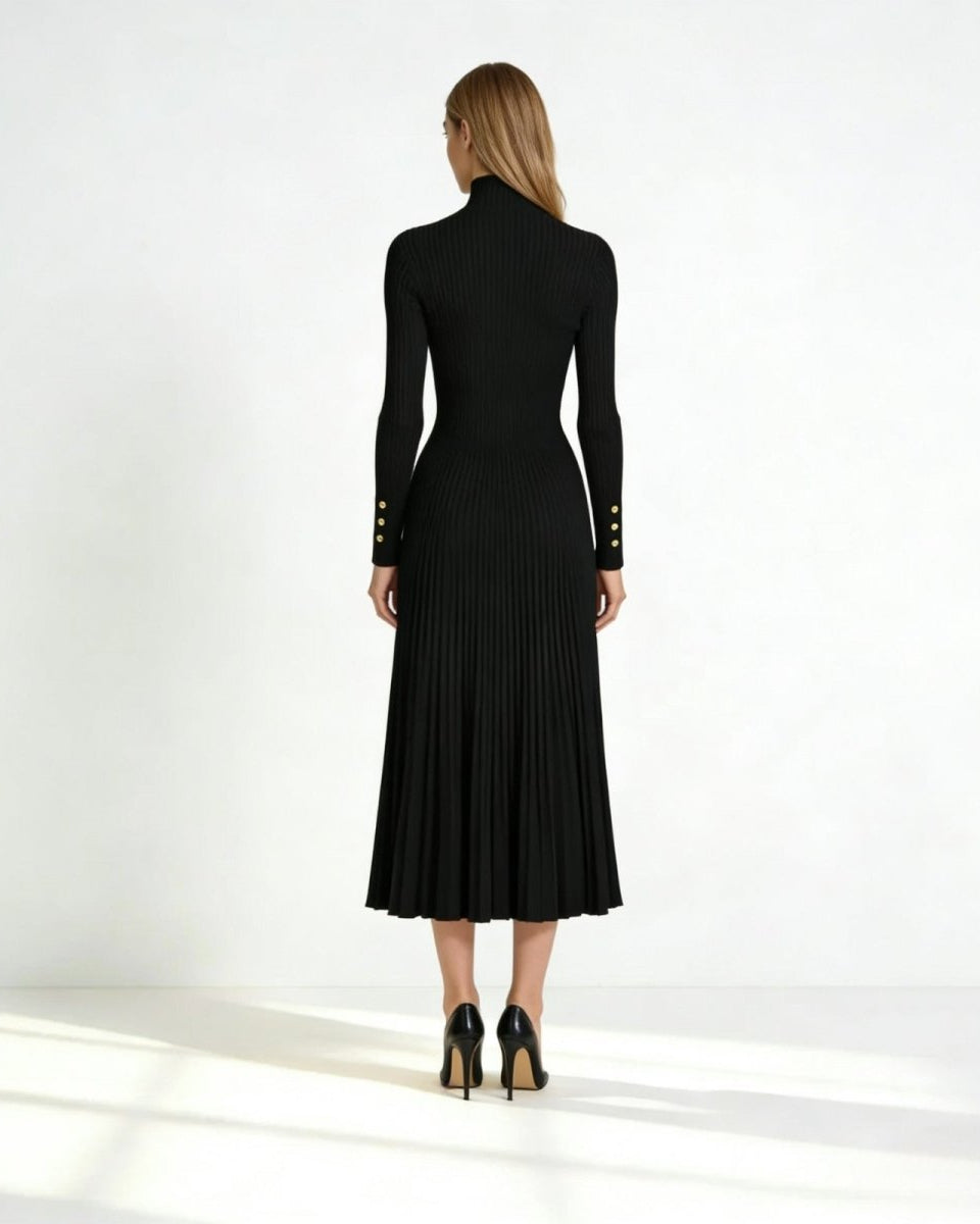 Back view of a model in the black knit midi dress, showing the form-fitting back and flow of the pleated skirt.