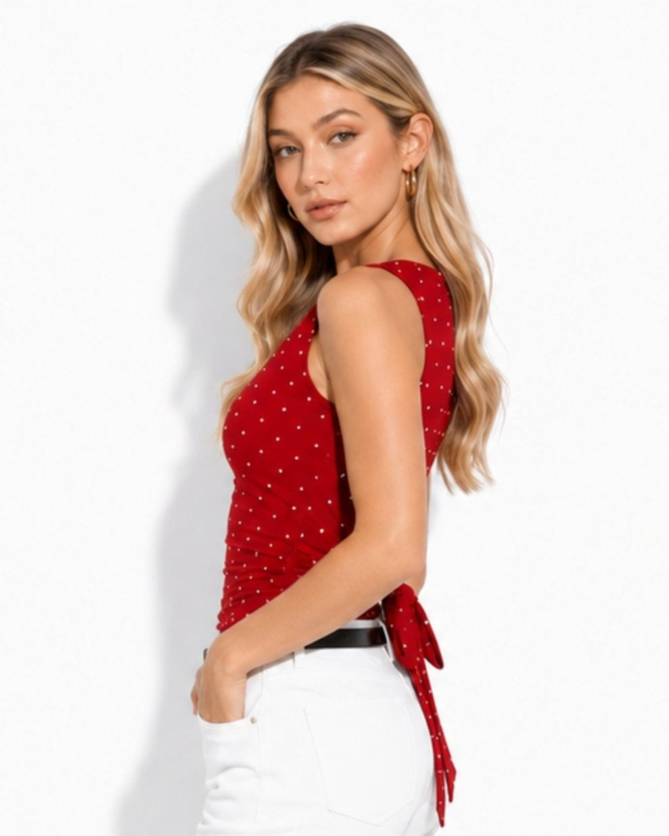Side profile demonstrating the form-fitting ruched bodice and back bow tie of the red polka dot backless shirt.