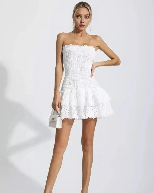 Woman wearing a white strapless dress on a plain background