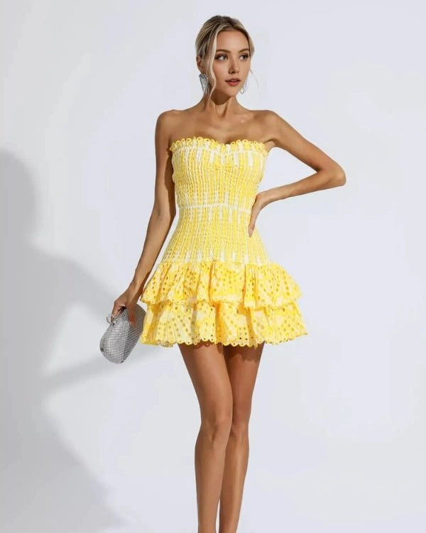 Woman wearing a yellow strapless dress on a white background