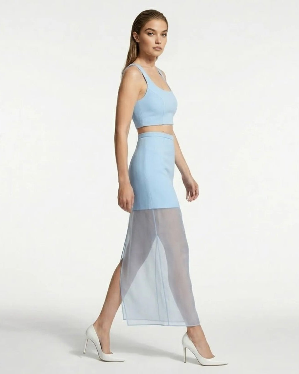Side profile of a contemporary light blue sheer overlay maxi skirt showing fluid movement, high waist fit, and sleek styling for party events.