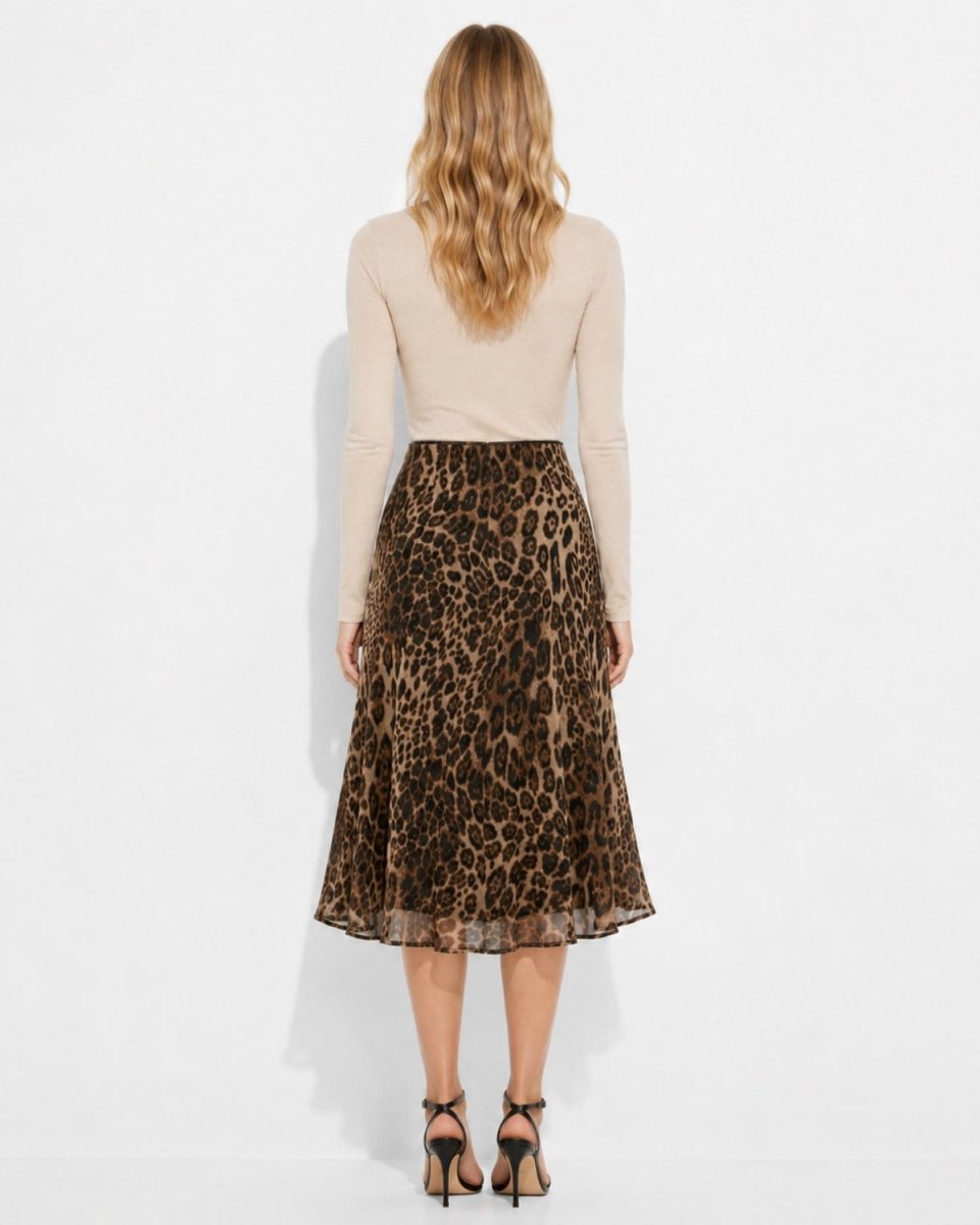 A woman shown from the back wearing a beige long-sleeve top and a brown leopard-print midi skirt, paired with black high-heeled sandals, against a plain white studio background.