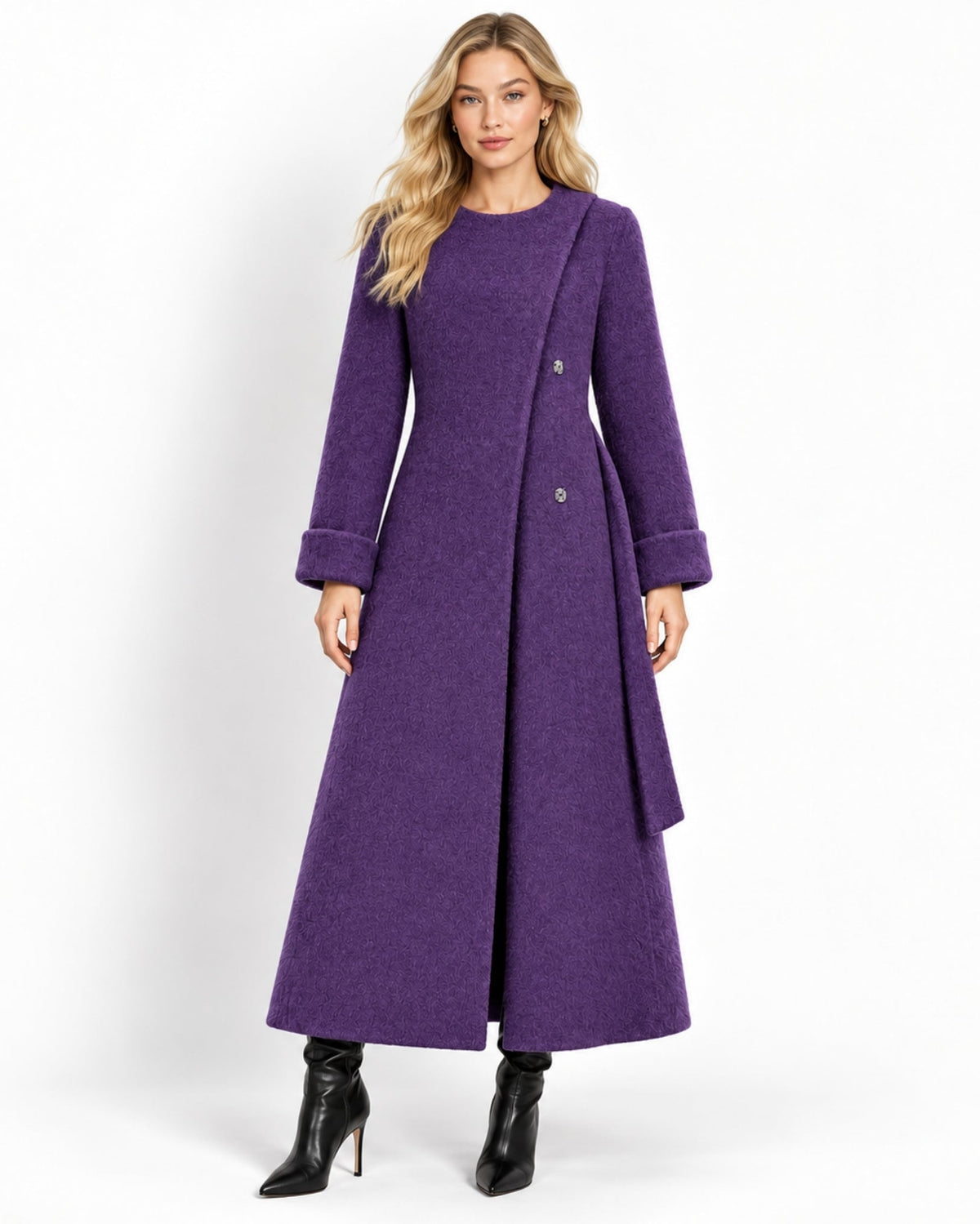 A woman modeling a long, wide purple coat with a round neckline, double-breasted buttons, and wide cuffs, paired with black ankle boots, against a plain white studio background.