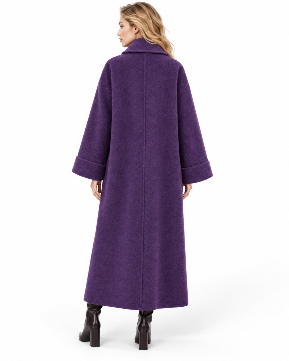 A woman viewed from the back wearing a long, wide-sleeved purple coat and black ankle boots against a plain white studio background.
