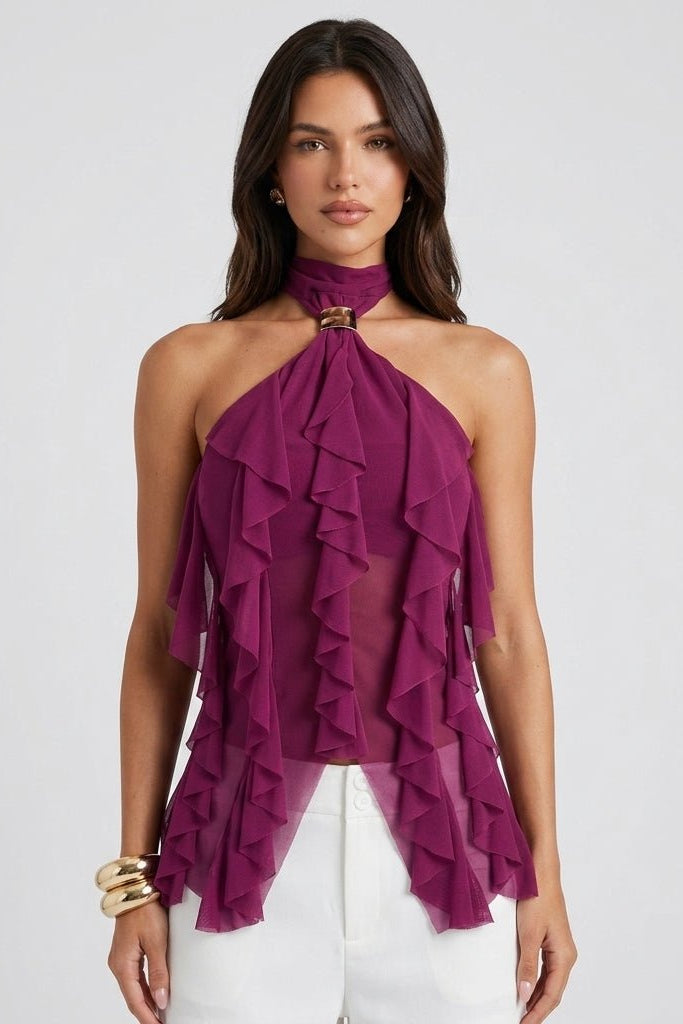 Woman wearing Fenlo Form purple cascading ruffle halter top with gold hardware and white trousers.