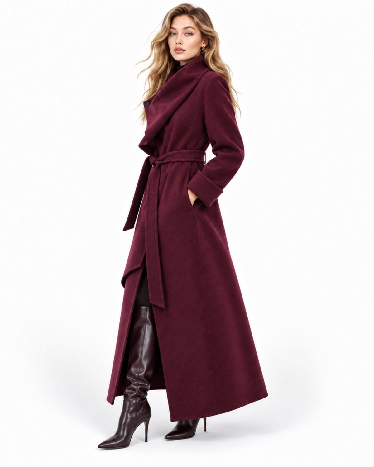 A woman modeling a long, dark burgundy wrap coat with a high collar and waist tie, paired with black leather knee-high boots, against a plain white studio background.