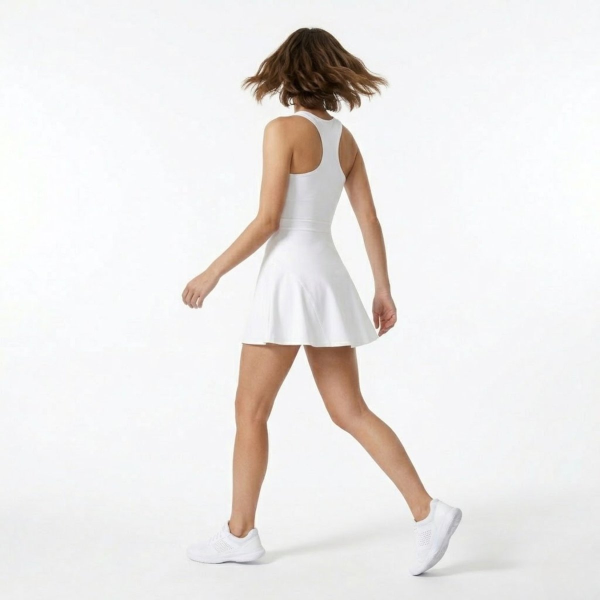 Back view showing the racerback design and flared skirt movement of the white premium activewear dress