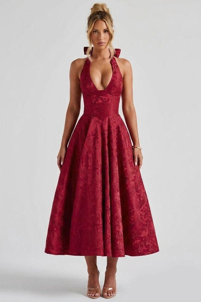 Front view of a woman wearing the Kouvr red floral jacquard halter neck midi dress featuring a structured corset bodice and deep plunging neckline.
