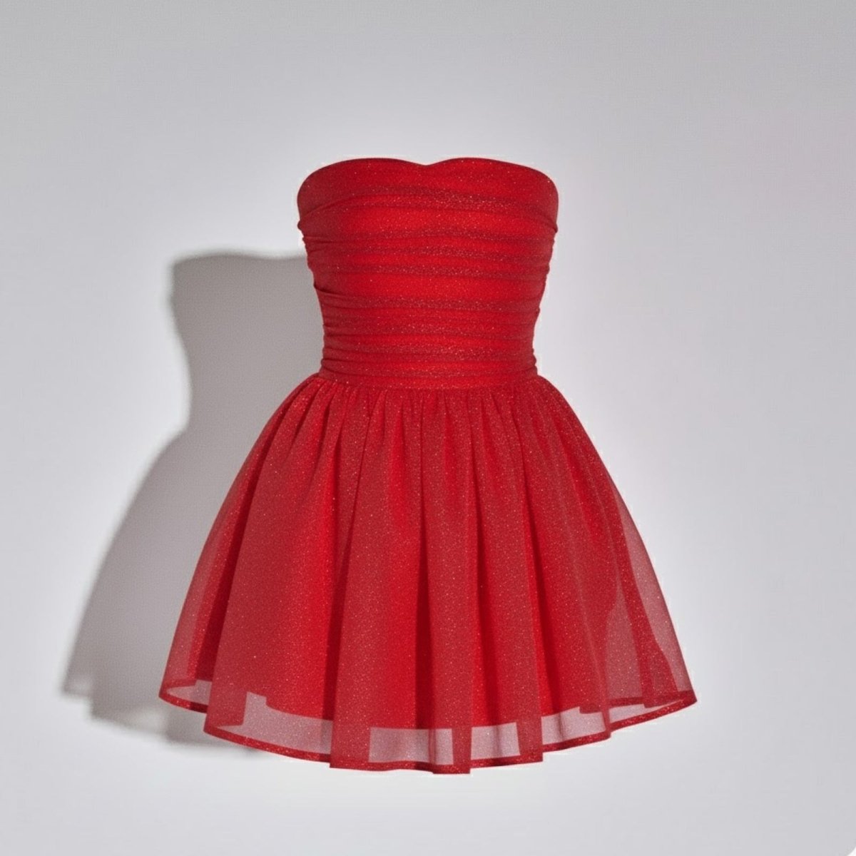 Model looking over her shoulder wearing the Kouvr Fashion red strapless mini dress, displaying the full back with the statement bow.