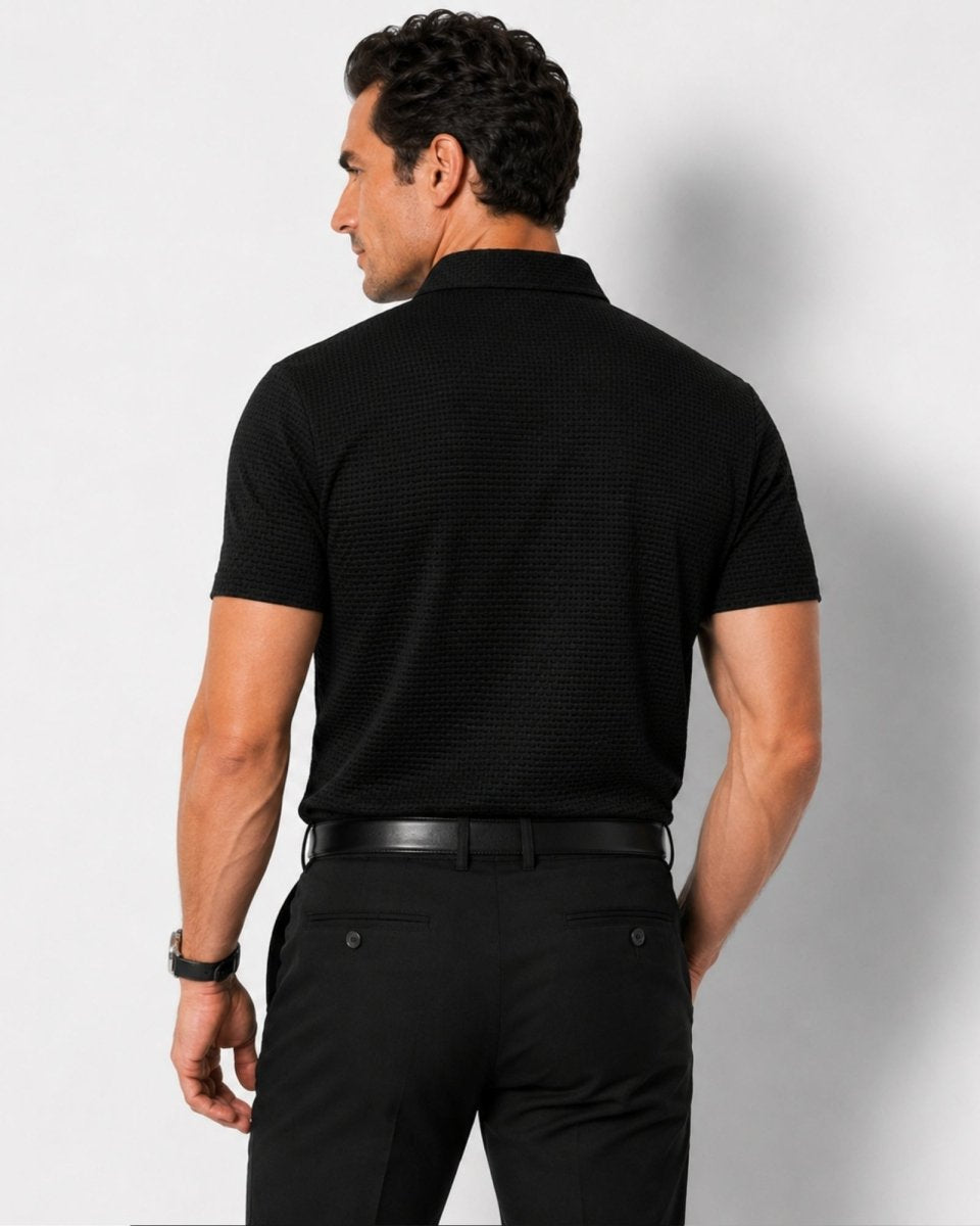 Man wearing a black polo shirt and pants against a white background