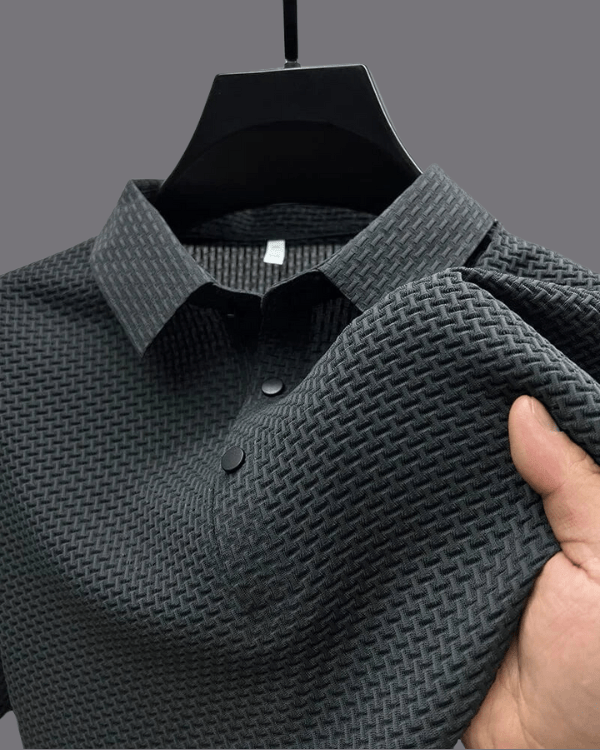 Dark gray textured shirt on a hanger with a hand touching the fabric.