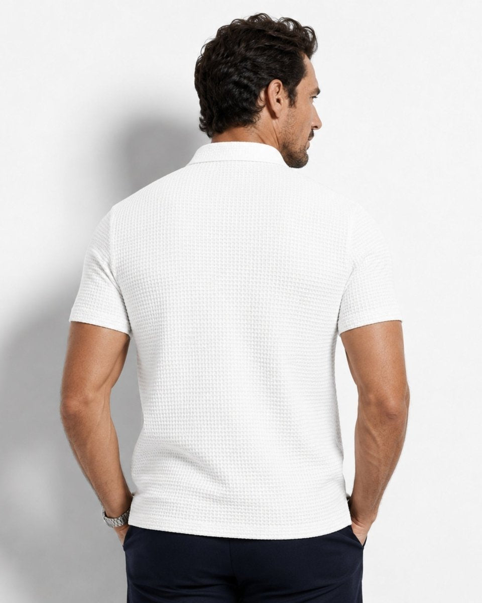 Man wearing a white textured polo shirt against a light gray background