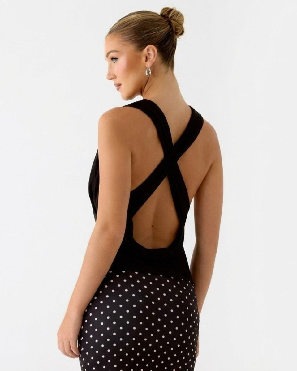 Side profile view of a woman wearing the Rhea open back top, showcasing the elegant criss-cross straps and draped design.