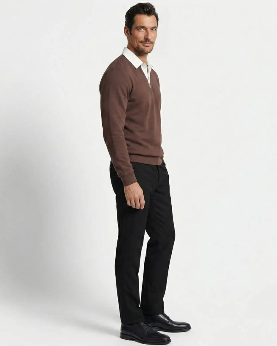 Side profile of a man in a dark brown knit polo sweater showing the tailored fit and silhouette against a white background.