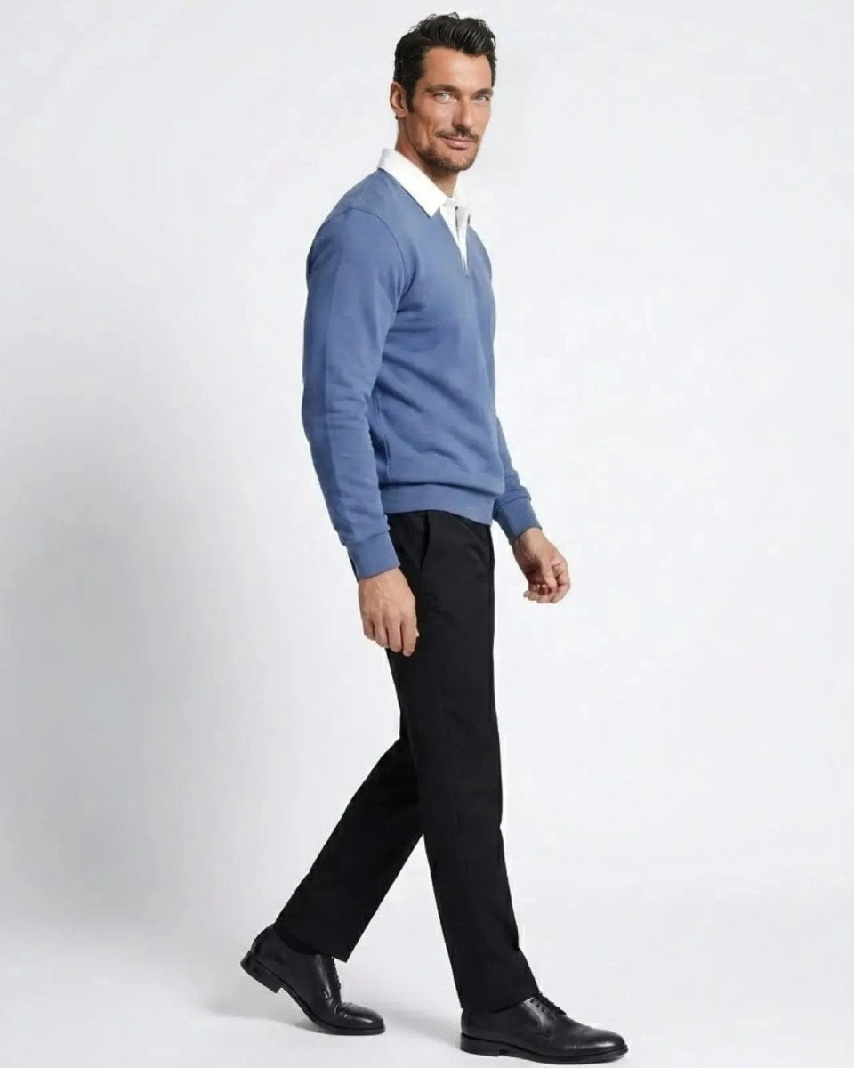 Side profile of a man walking while wearing the steel blue Rhodes polo sweater, showcasing its tailored fit and drape.