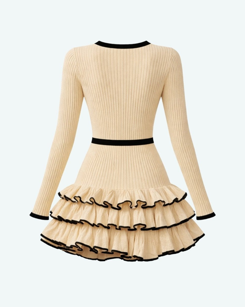Flat lay back view of a beige and black knit ruffle mini dress highlighting the ribbed texture and contrast borders.