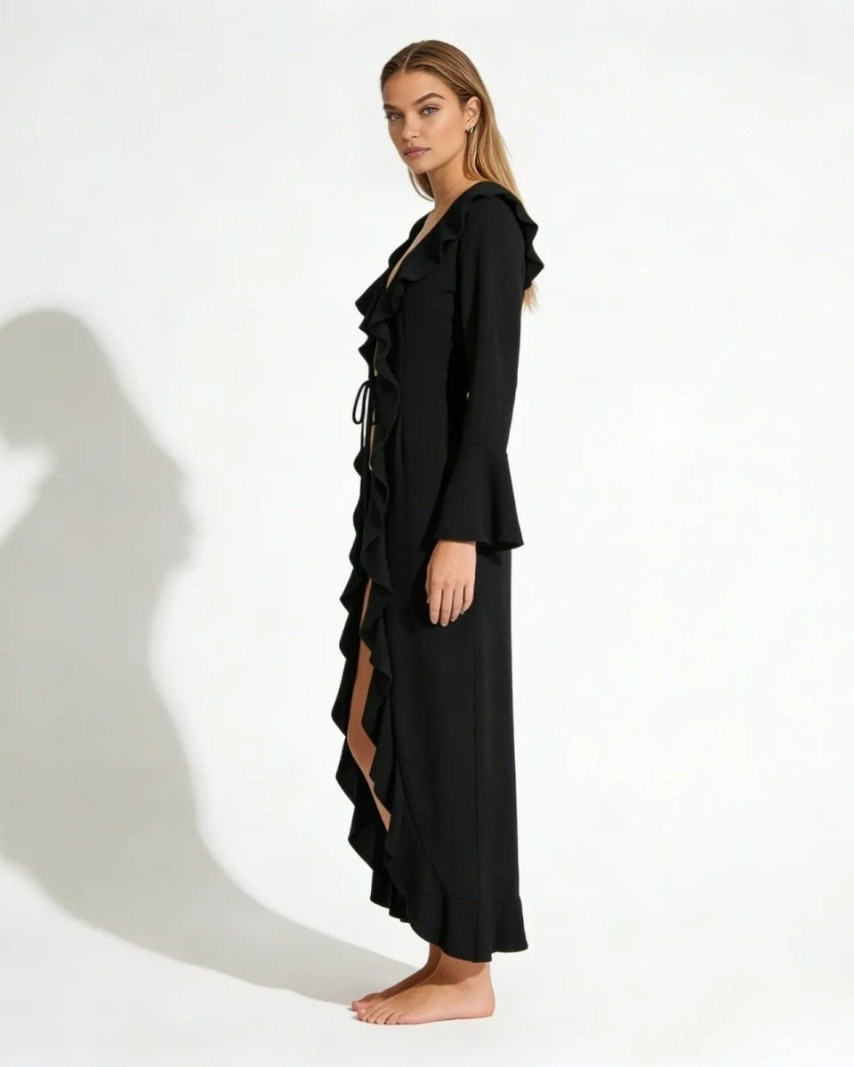 Side profile of a model in the Roseta black maxi robe, highlighting the flared bell sleeves and flowing silhouette.