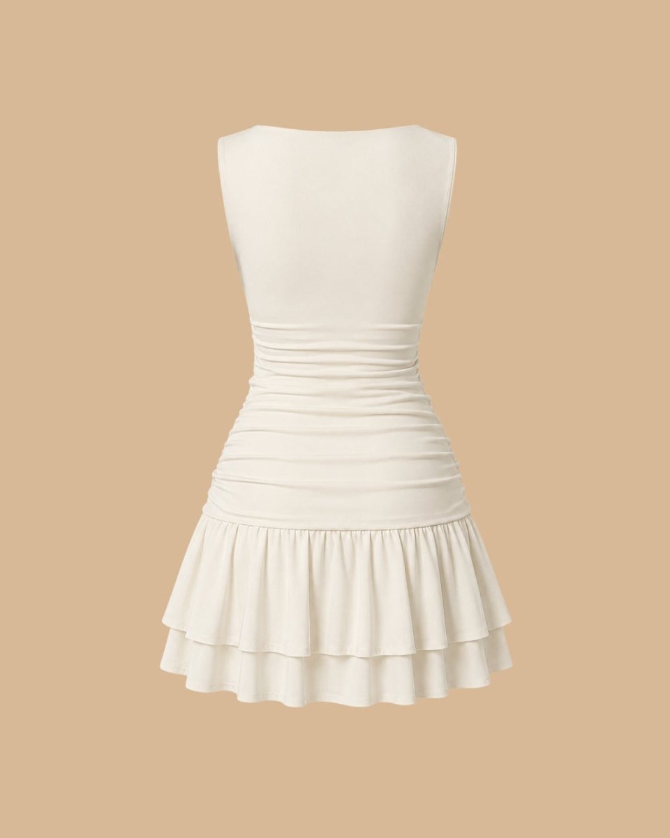 An off-white sleeveless mini dress with a ruched waist and a tiered ruffled skirt, shown from the back against a solid beige background.
