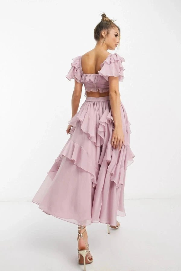 Model wearing fenlo formFreyna dusty lilac two-piece ruffle dress with corset top and tiered midi skirt