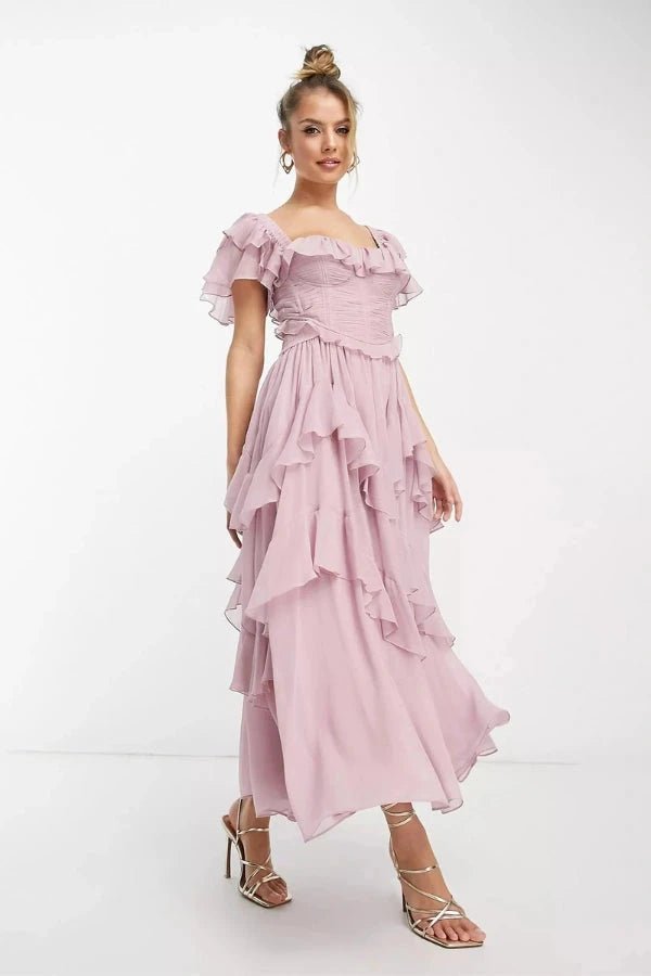 Model wearing Fenlo Form Freyna dusty lilac two-piece ruffle dress with corset top and tiered midi skirt