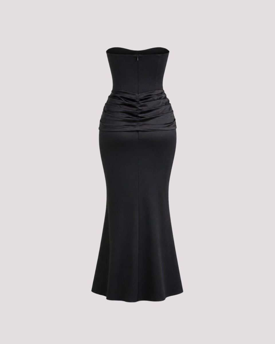 A black strapless mermaid-style gown with a structured sweetheart neckline, ruched gathered waist, and flared skirt, shown on a plain light gray background.