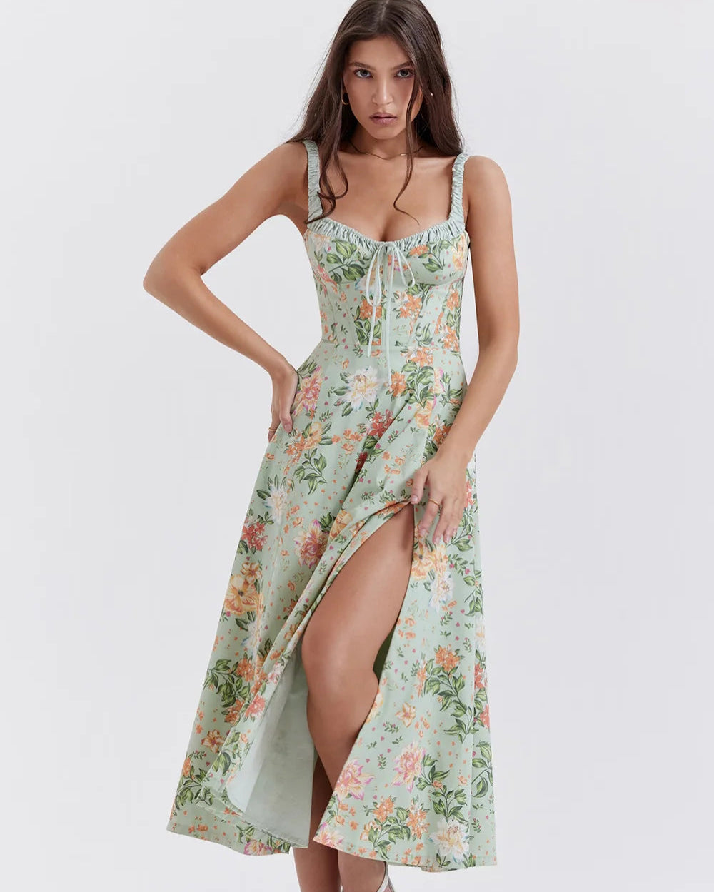 Woman wearing a floral dress with a slit on a white background