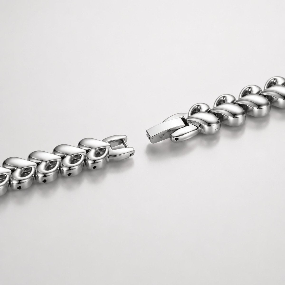 Extreme close up of the durable and elegant silver interlocking heart links and secure jewelry clasp of the Kouvr women's watch.