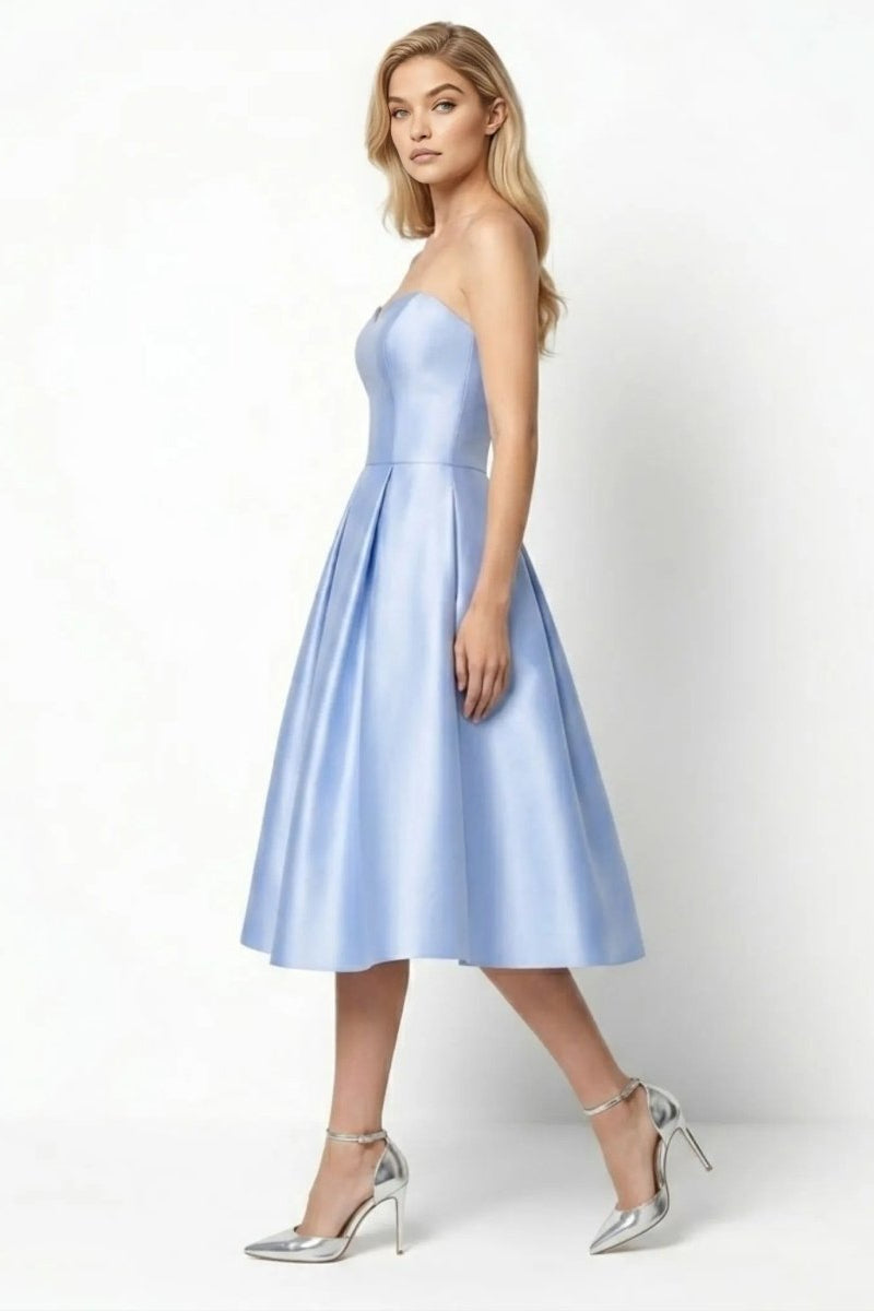Side profile of woman modeling the powder blue formal tea length cocktail dress showing fitted bodice structure