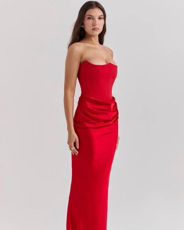 Woman wearing a strapless red evening gown on a light gray background