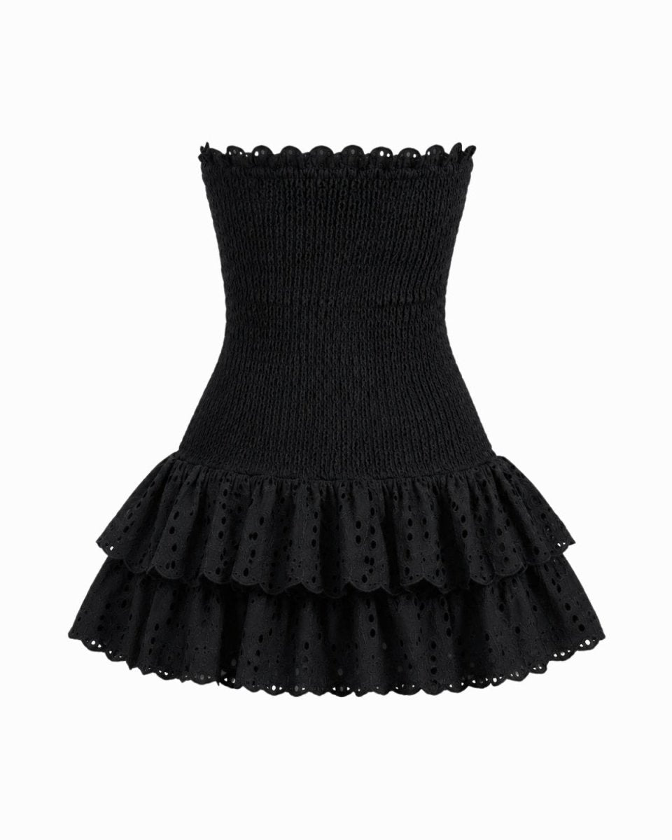 A black strapless mini dress featuring a ribbed knit bodice, scalloped eyelet lace trim, and a tiered ruffled skirt, shown against a plain white background.
