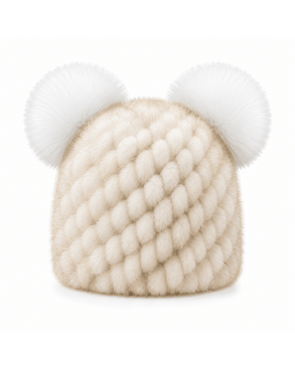 A cream-colored fur hat featuring a textured diamond pattern and two fluffy white pom-poms on top, set against a plain white background.