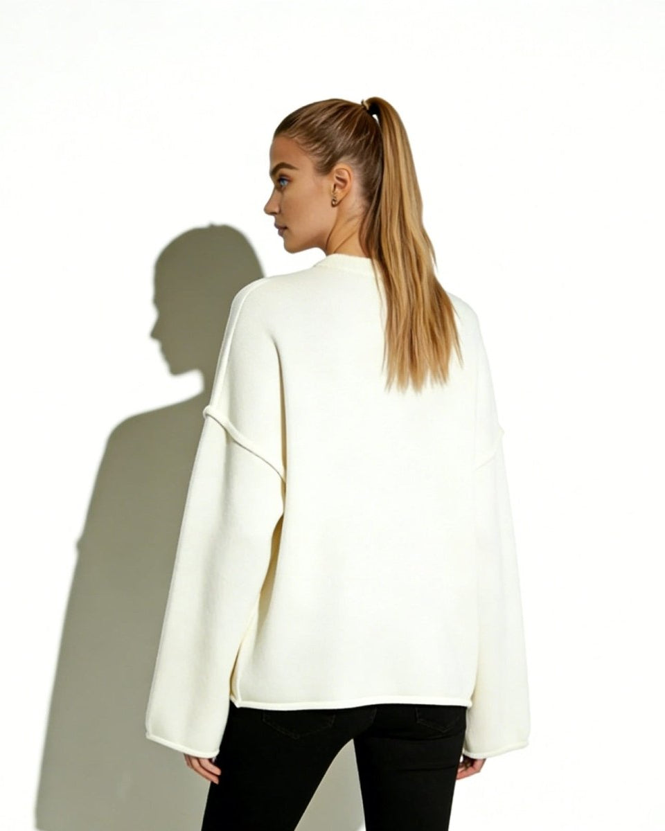 Back view of the minimalist ivory knit pullover on a model, highlighting the clean architectural lines and relaxed oversized fit.