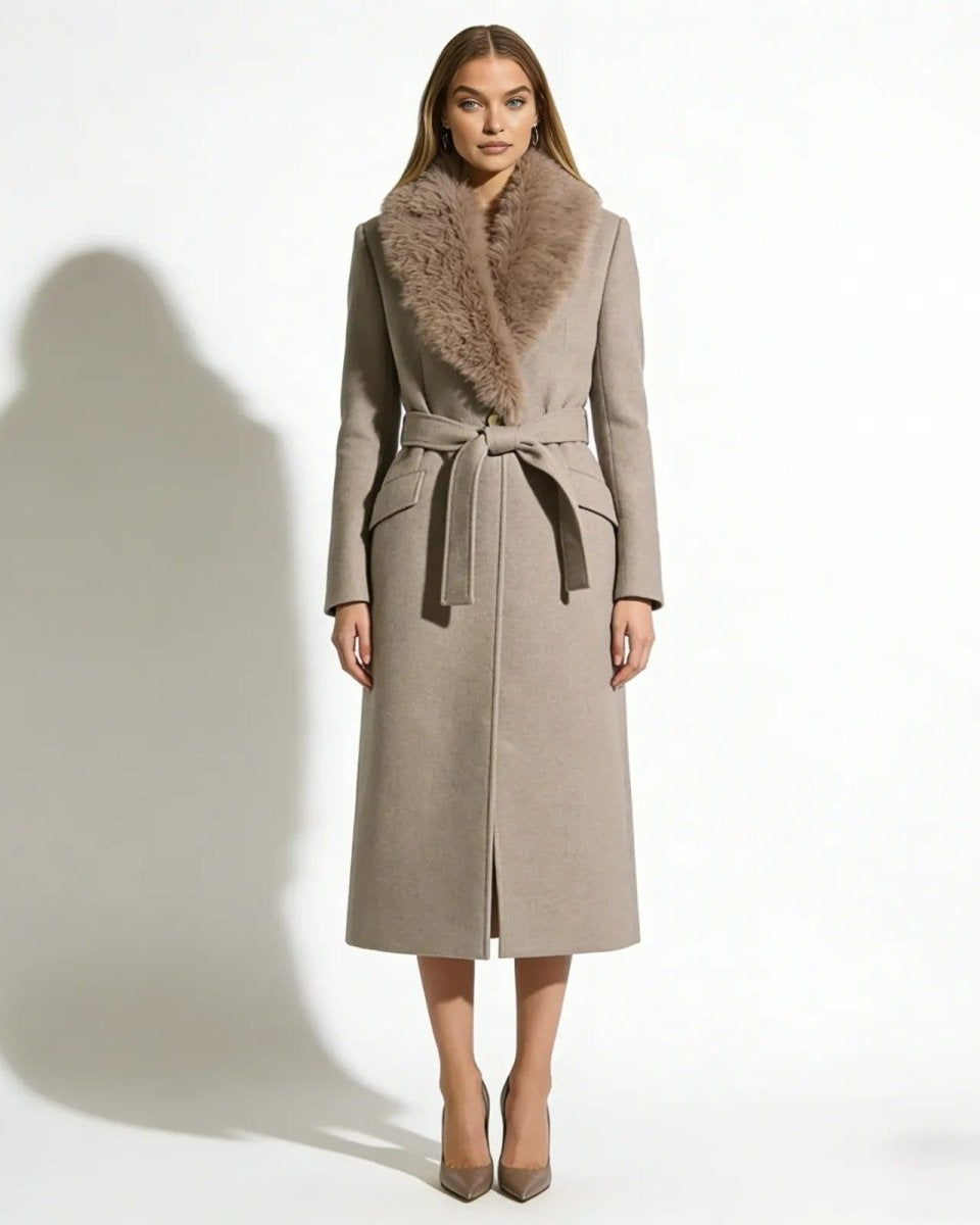 A woman wearing the Trisha long oatmeal khaki wool wrap coat with a plush shearling fur collar, tied at the waist.