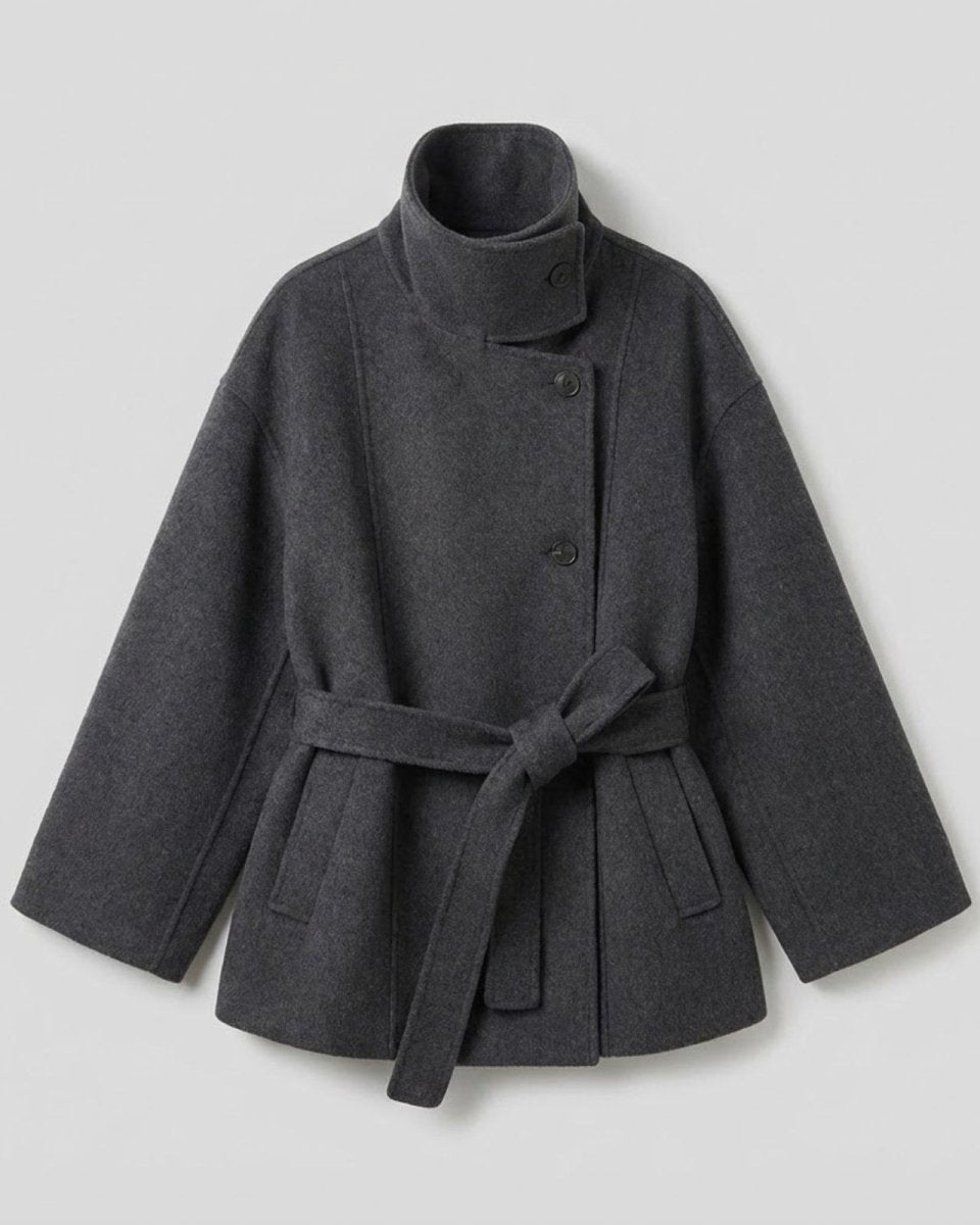 Flat lay of the dark gray verna funnel neck coat, showing the asymmetrical button closure and tie belt.