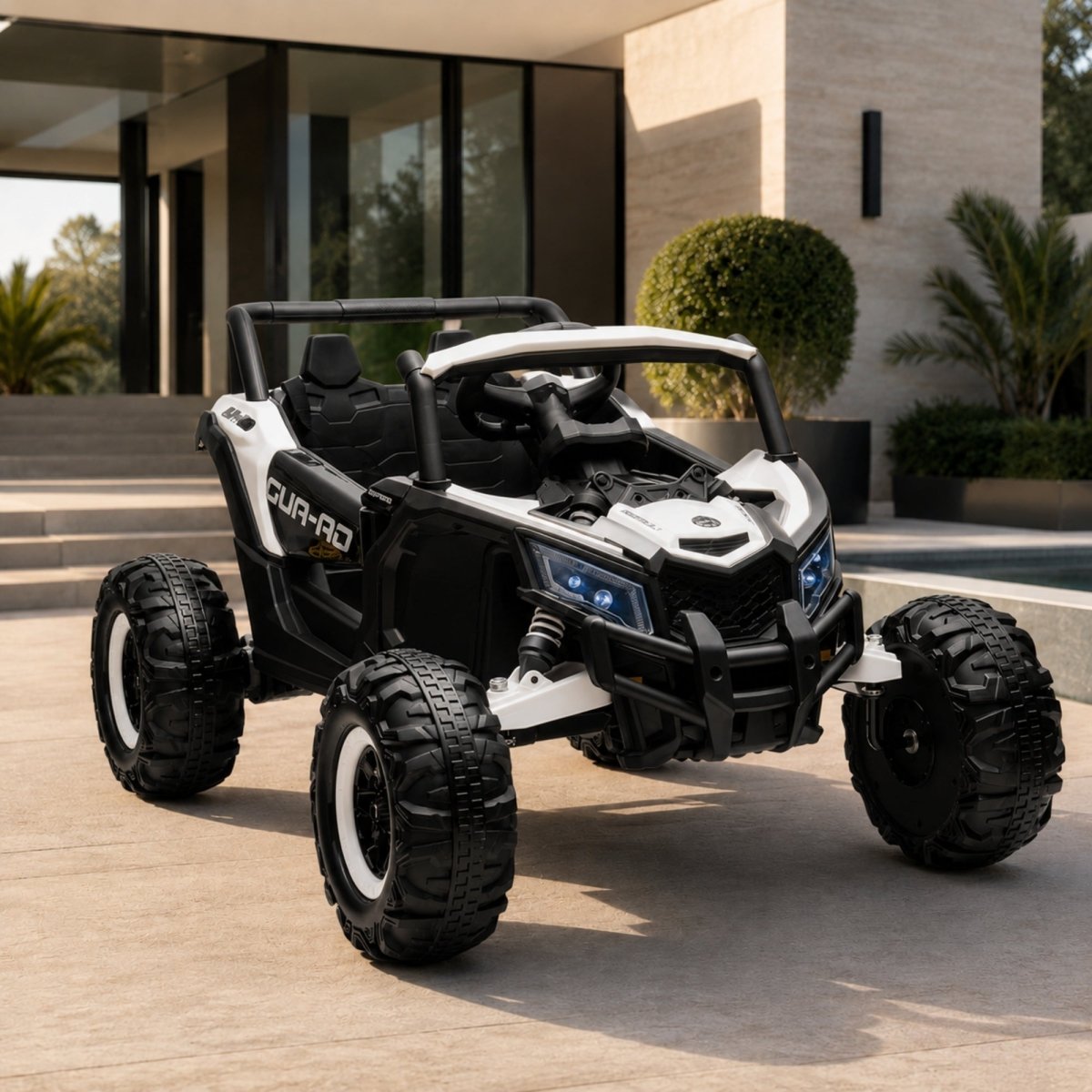 A white and black two-seater kids' electric UTV side-by-side vehicle parked on a luxury home patio with blue LED headlights turned on.