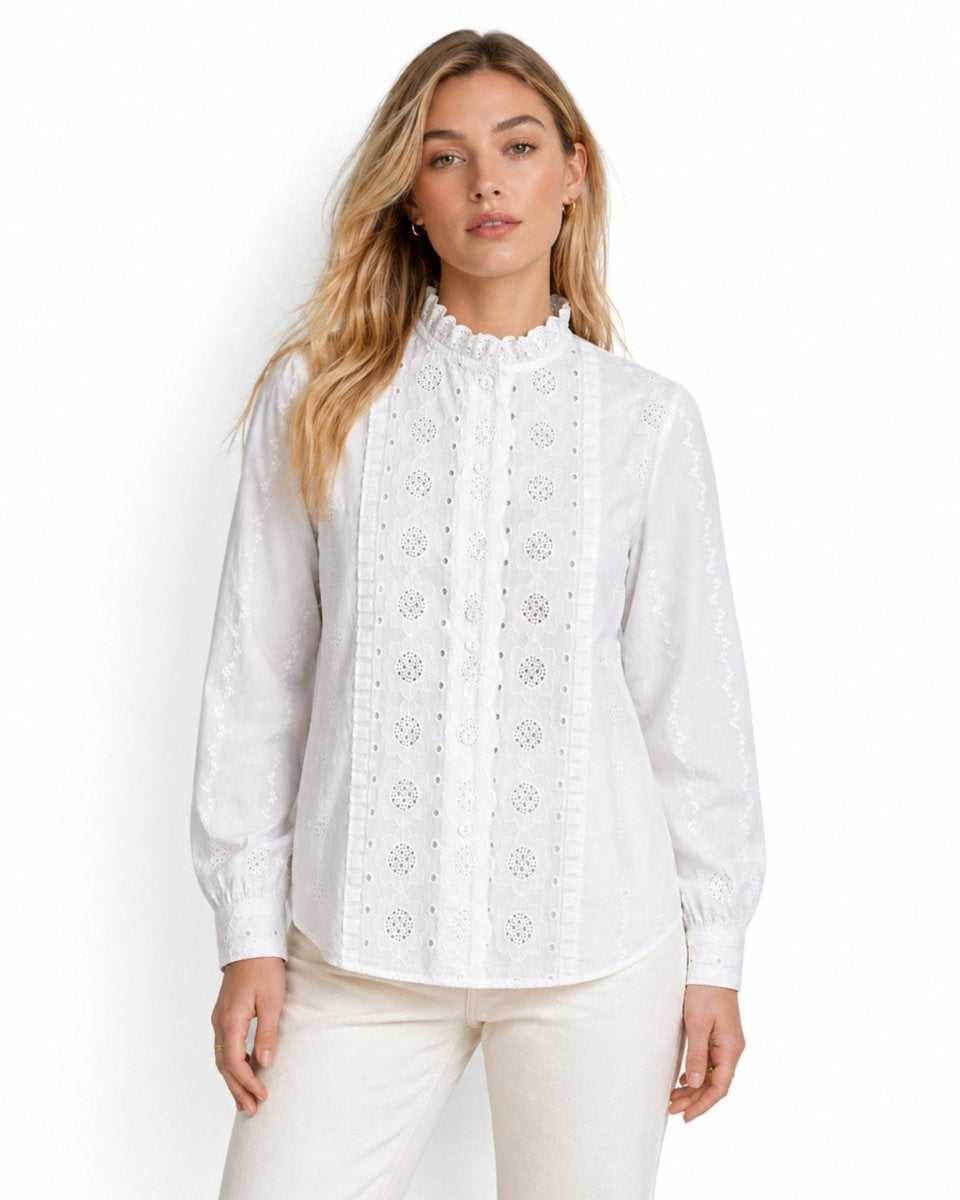 Front view of woman wearing white broderie anglaise high neck blouse with long sleeves
