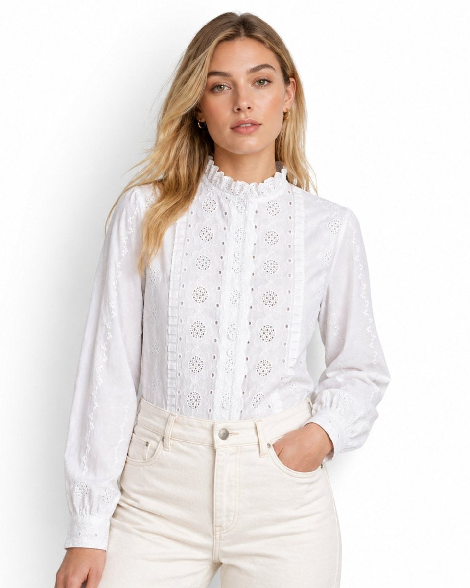 Lifestyle shot of woman with hand in pocket wearing white eyelet ruffle neck blouse