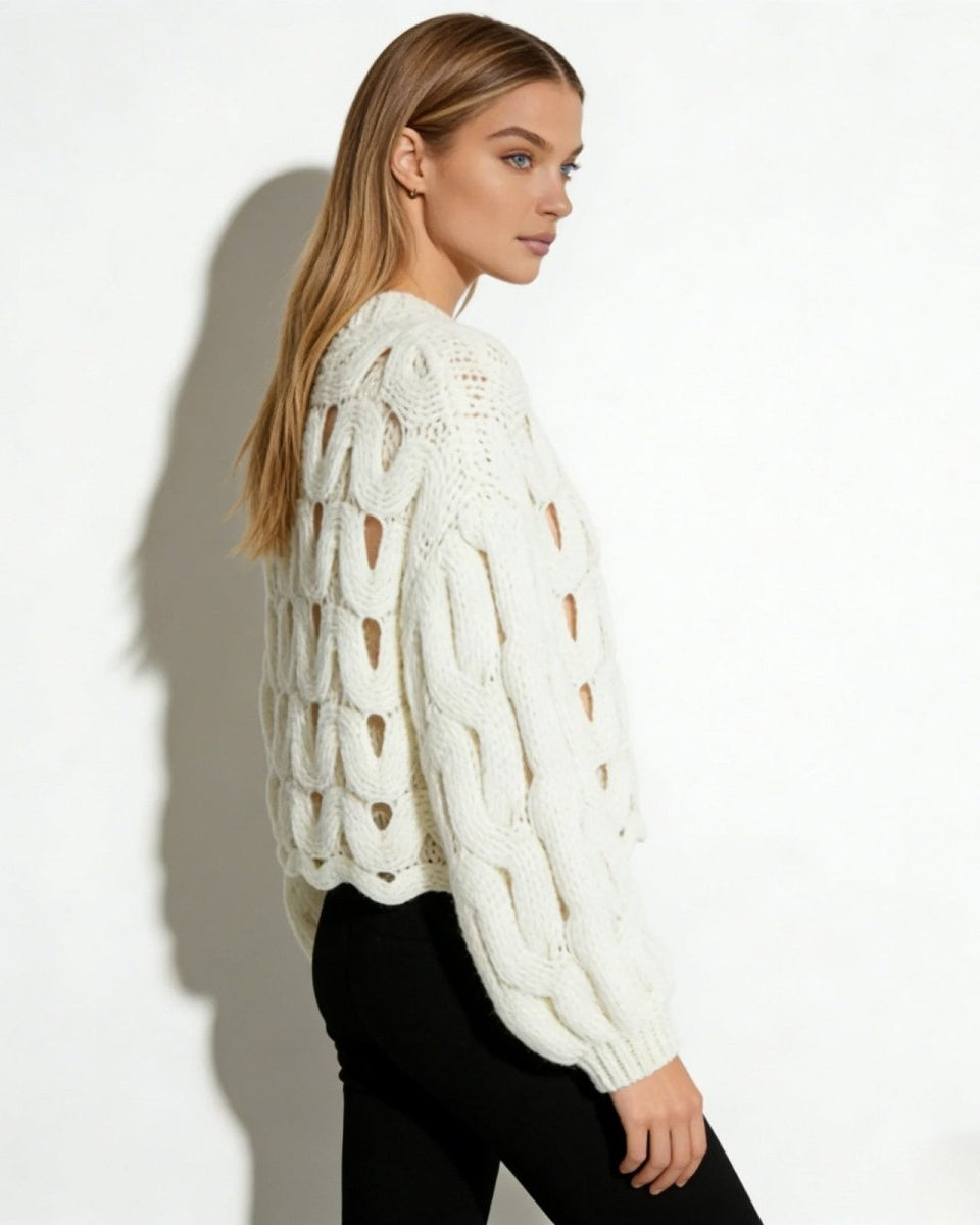 Side profile of a model in the white cutout chunky knit sweater, highlighting the voluminous balloon sleeve and open-weave detail.